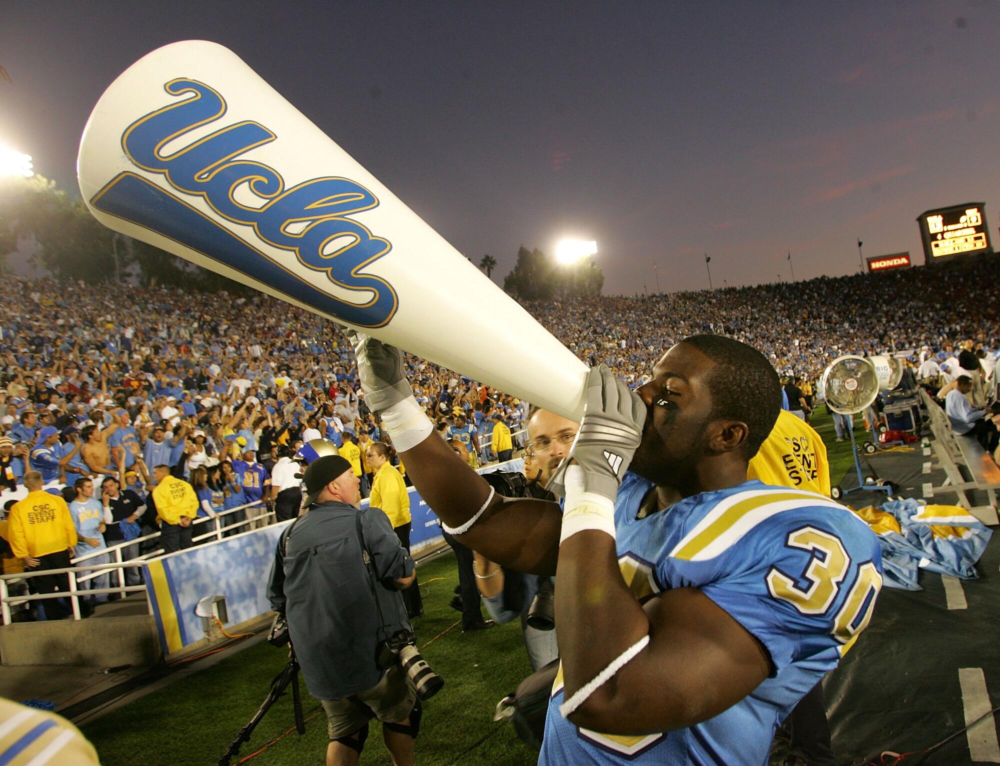 UCLA tailback Derrick Williams celebrates with a cheerleader's megaphone after defeating the USC at the Rose Bowl.