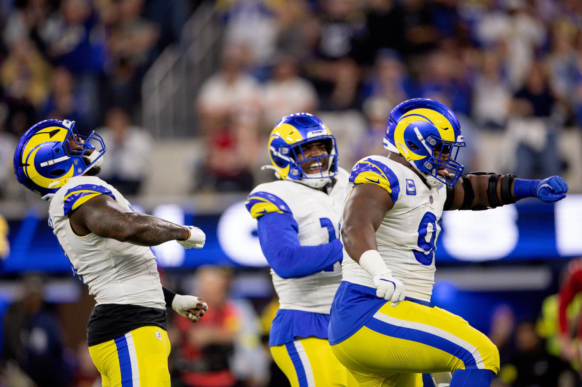 Rams linebackers Jared Verse, left, and Josaiah Stewart, center, and defensive end Kobie Turner celebrate in the first half.