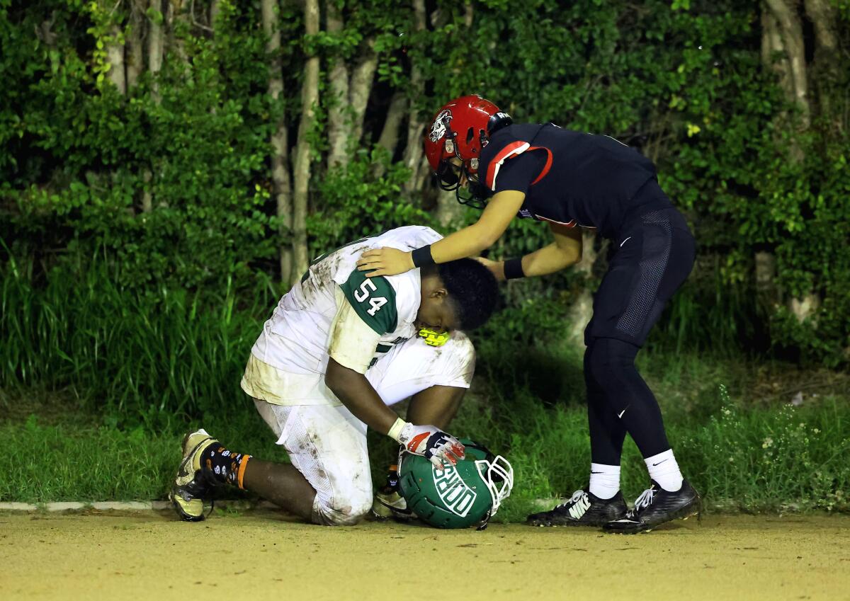 South Gate quarterback Michael Gonzalez tries to console William Smith of Dorsey