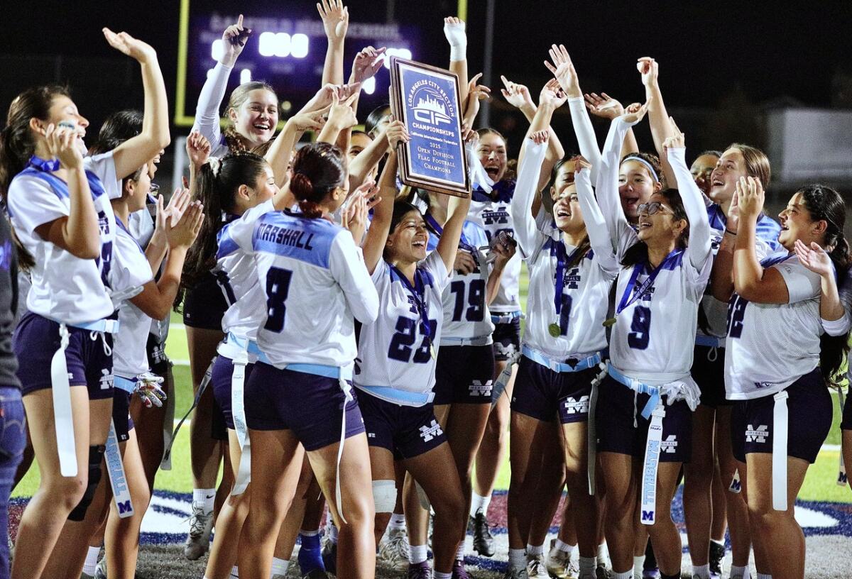 Alexa Guerrero holds the championship plaque as she and her Los Angeles Marshall teammates celebrate.