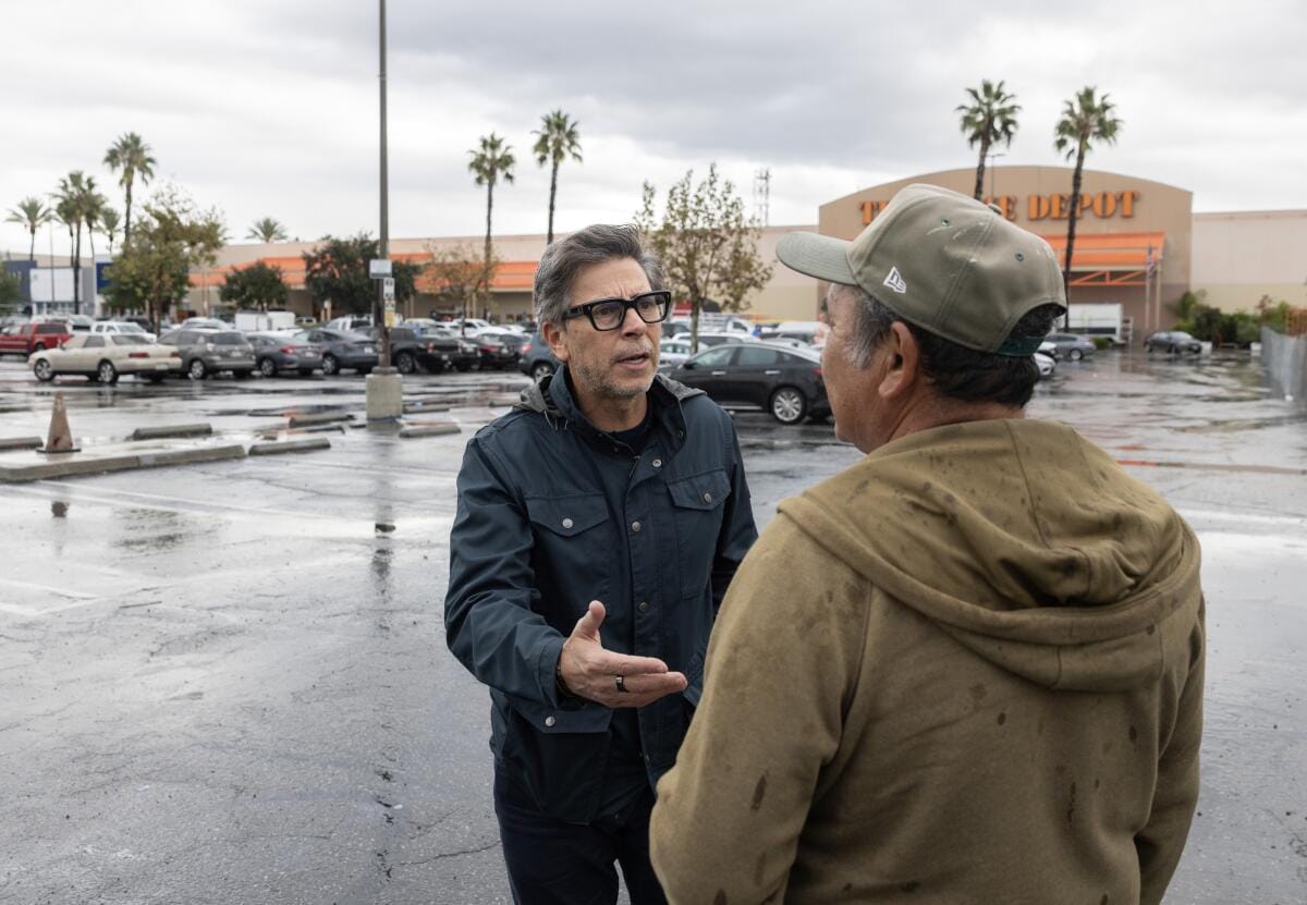 A man talks to another man.