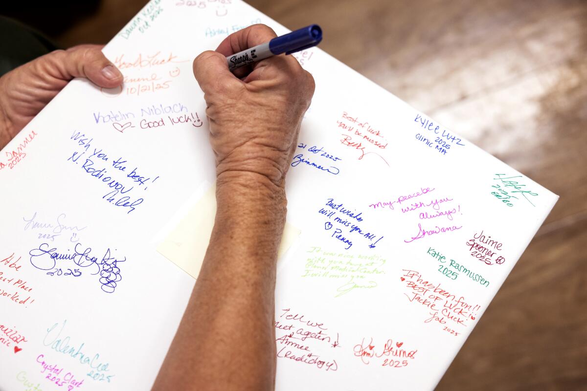 T-Ann Pearce signs a farewell board on closing day