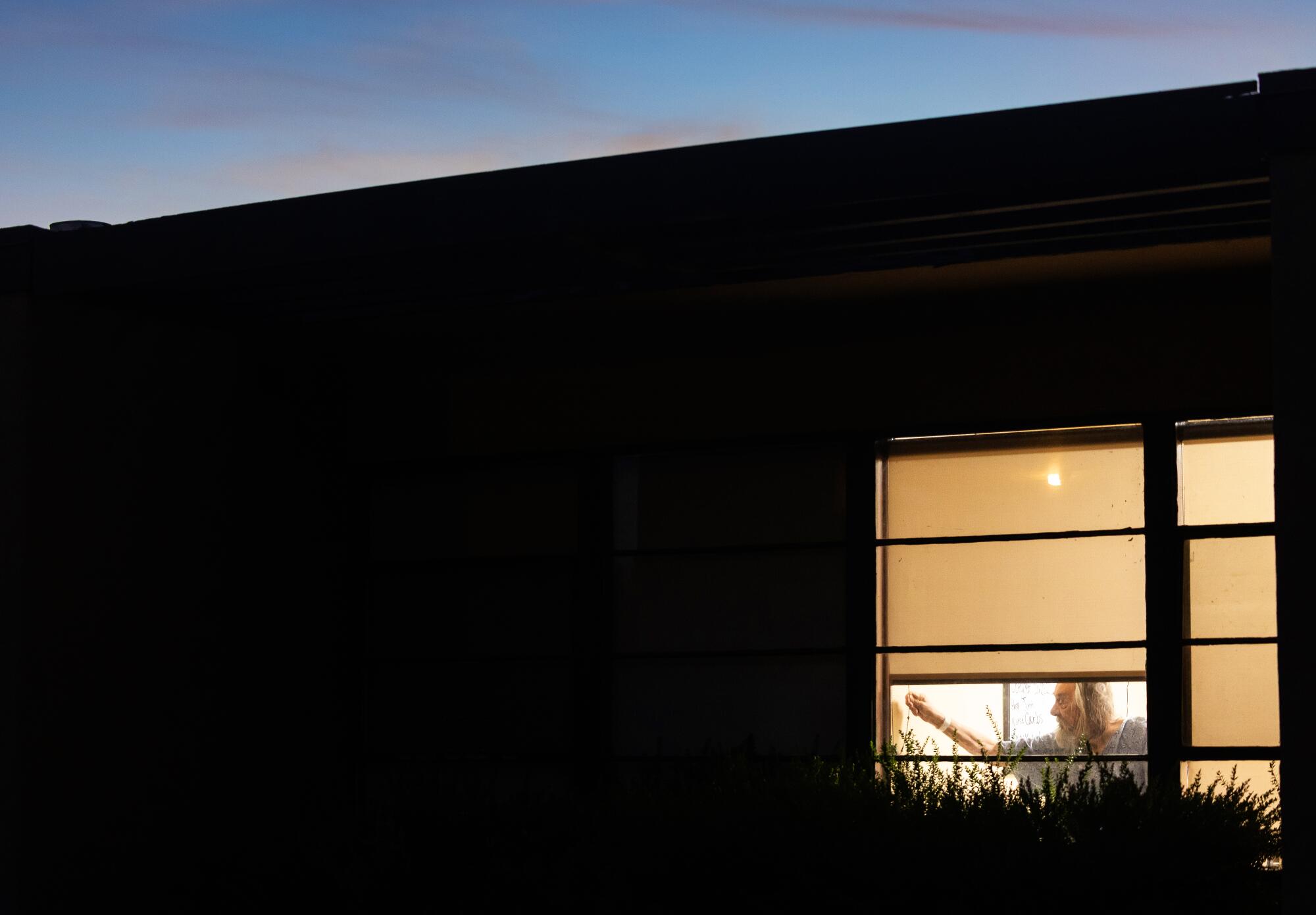 Glenn Medical Center patient Richard Putnam, 86, closes the window