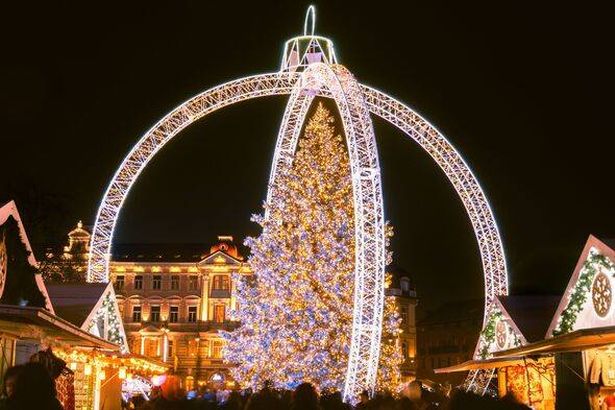 Vilnius, Lithuania - 30th november, 2024: close up people visitors in motion shopping on Xmas market sightseeing beautiful Xmas tree in city Vilnius -