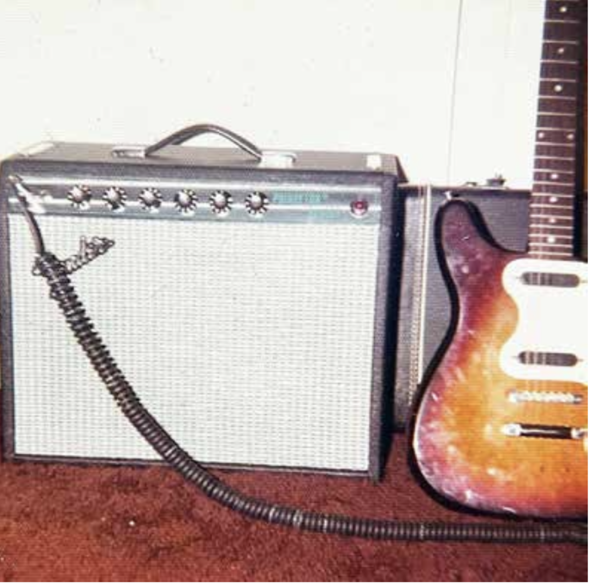 An amp sits by a guitar.