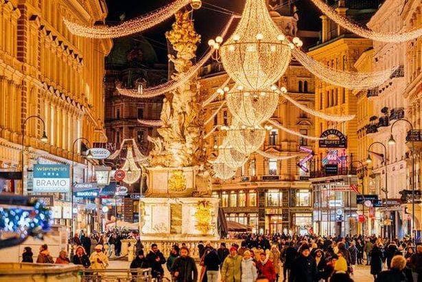 Brightly illuminated chandelier Christmas decoration on Graben shopping street in winter, Vienna, Austria