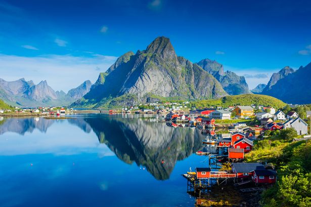 Perfect reflection of the Reine village on the water of the fjord in the Lofoten Islands, Norway