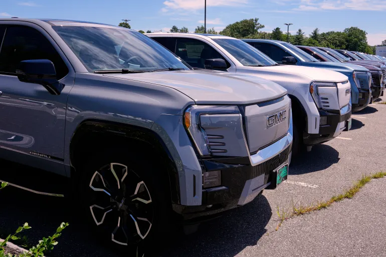 A selection of 2025 GMC Sierra EV Denali pick-up trucks, which are fully electric vehicles, are displayed at a GMC/Hummer truck dealership, Friday, July 18, 2025, in Manchester, N.H. (AP Photo/Charles Krupa)