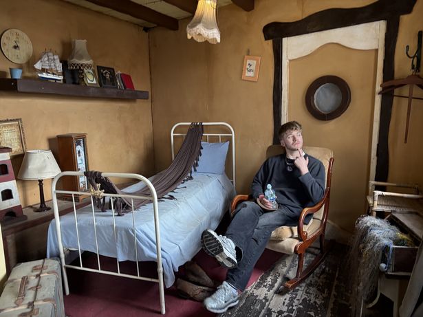 Man sitting on a prop chair within movie set 