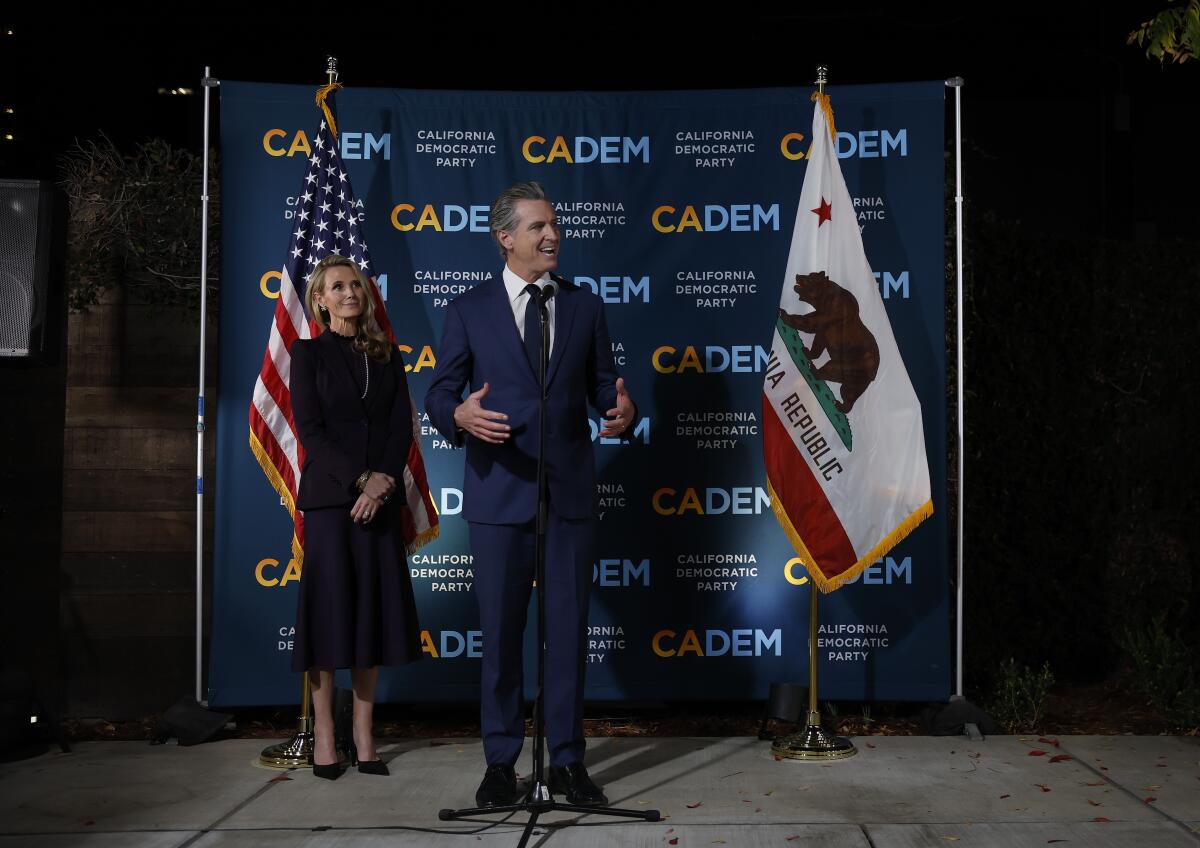 Gov. Gavin Newsom speaks as his wife Jennifer Siebel Newsom looks on