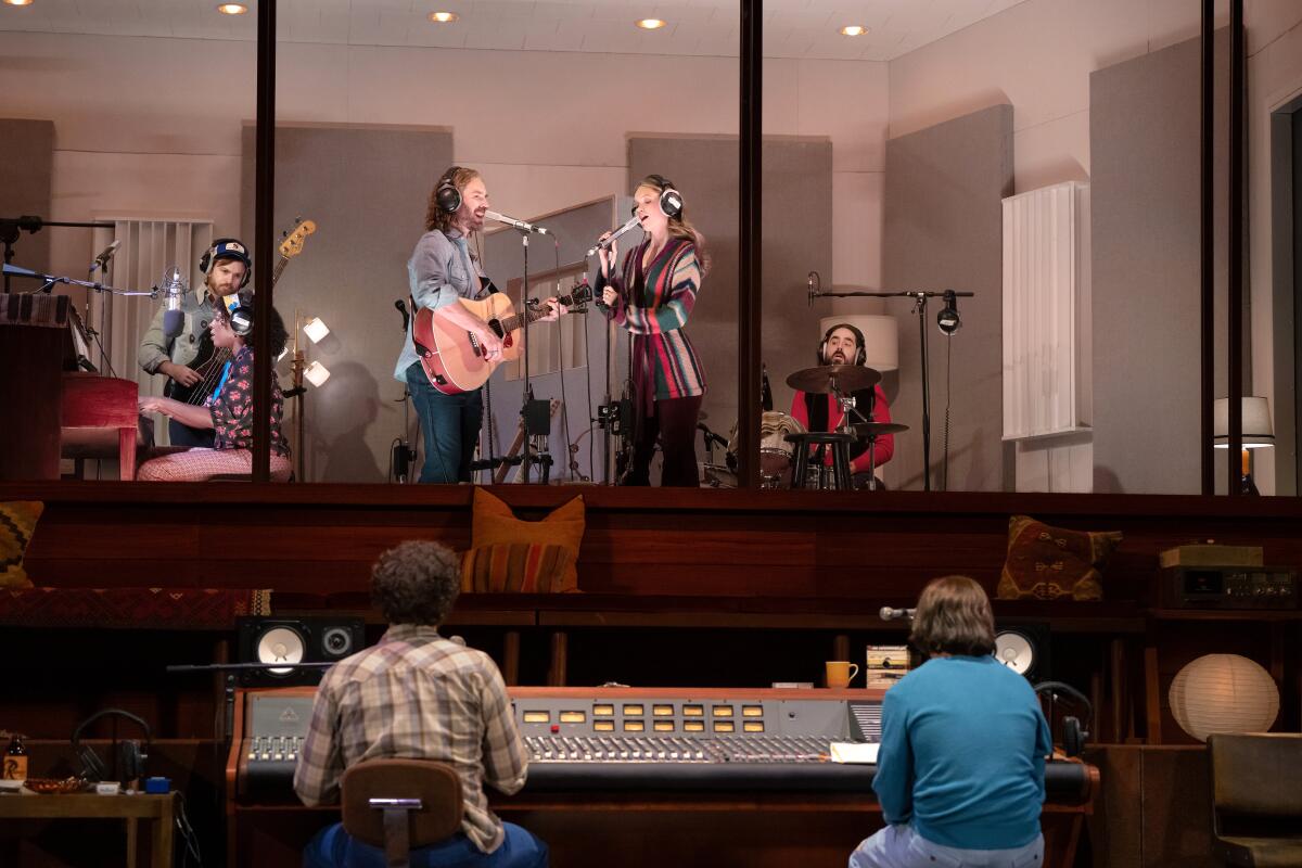 Musicians record music in a sound room as engineers watch outside in "Stereophonic."