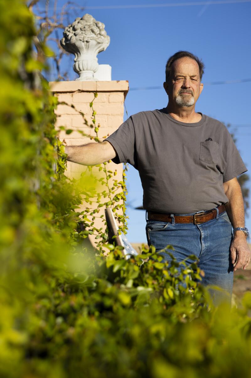 Tom Doran poses for a portrait in the remains of his home