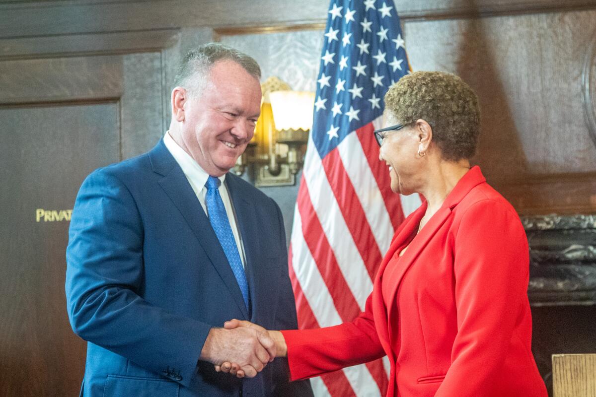 Jim McDonnell and Karen Bass shake hands