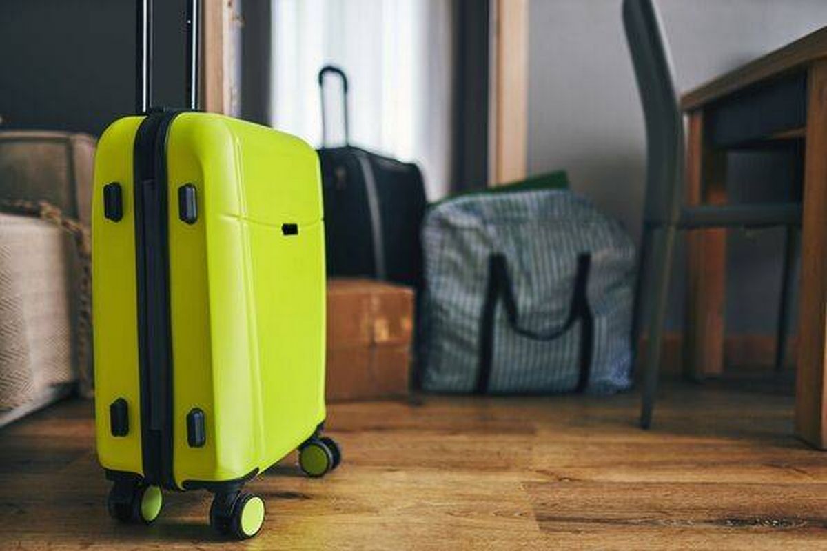 Bright Lime Green Suitcase On Wooden Floor In Cozy Living Space With Bags And Desk