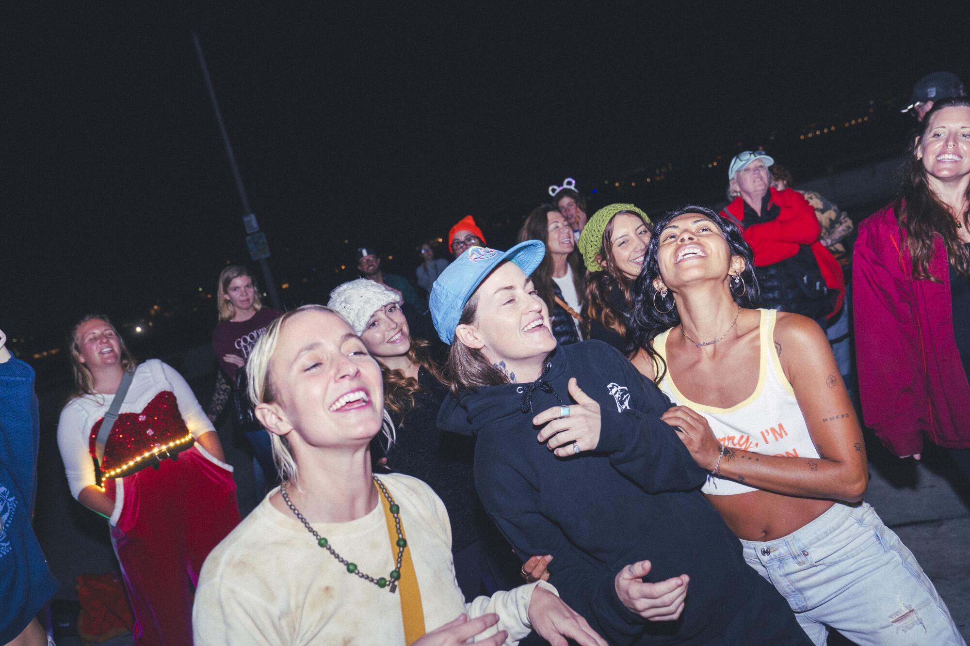 Lindsey Klucik, left, dances with friends to Christmas songs at the Venice Pier during a GrlSwirl group skate.