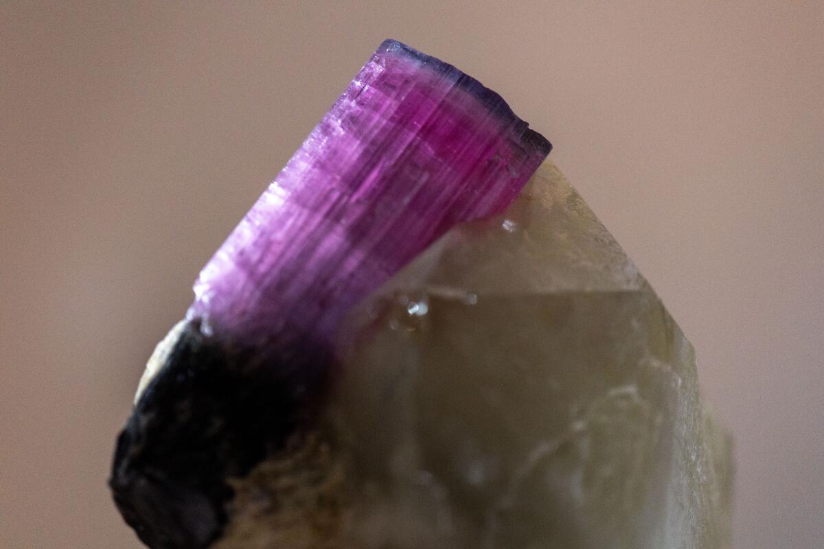 A milky white crystal with a large pink crystal through its top section.