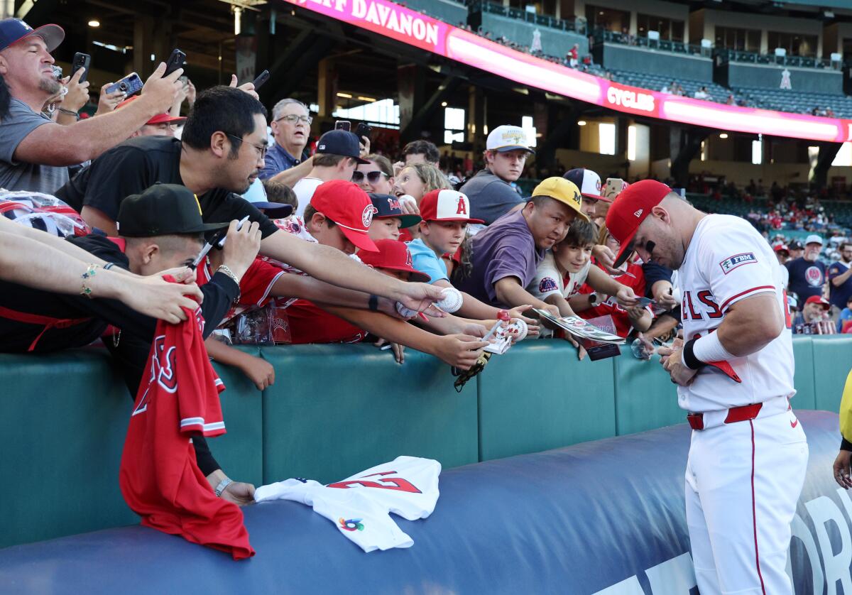 Angels star Mike Trout signs autographs for fans before a game against the Minnesota Twins at Angel Stadium on Sept. 8.