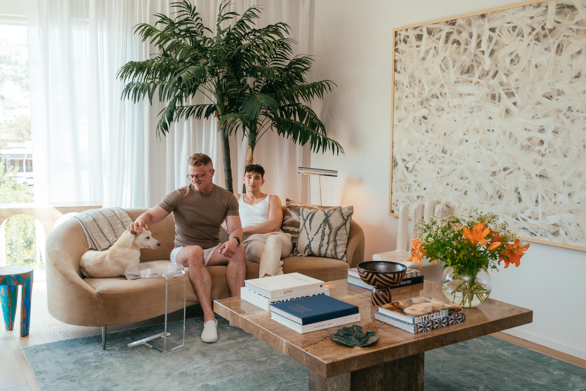 Two people and a dog on a couch.