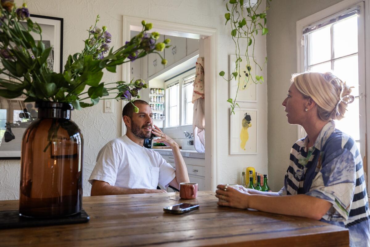 Samuel Gibson and wife Natalie Babcock at a table near a vase of flowers.