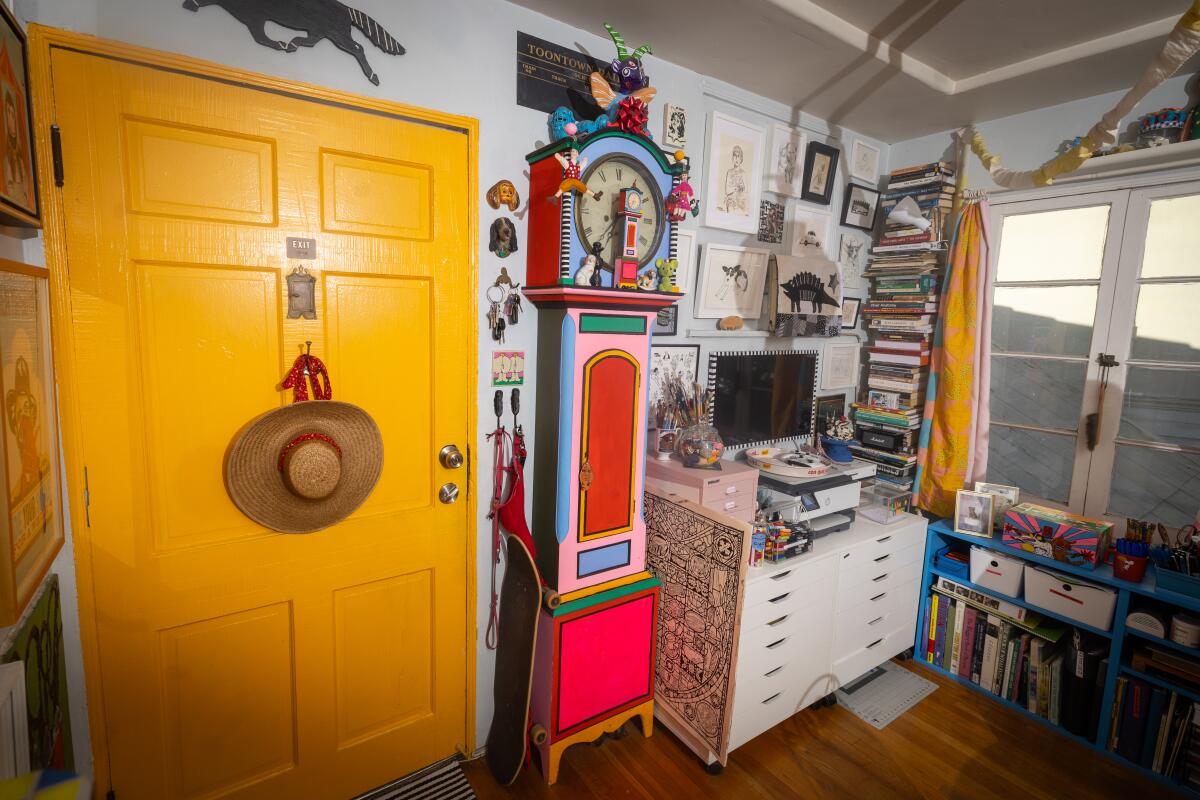 The living room and work station area with colorful artwork and a black-and-white striped sofa.