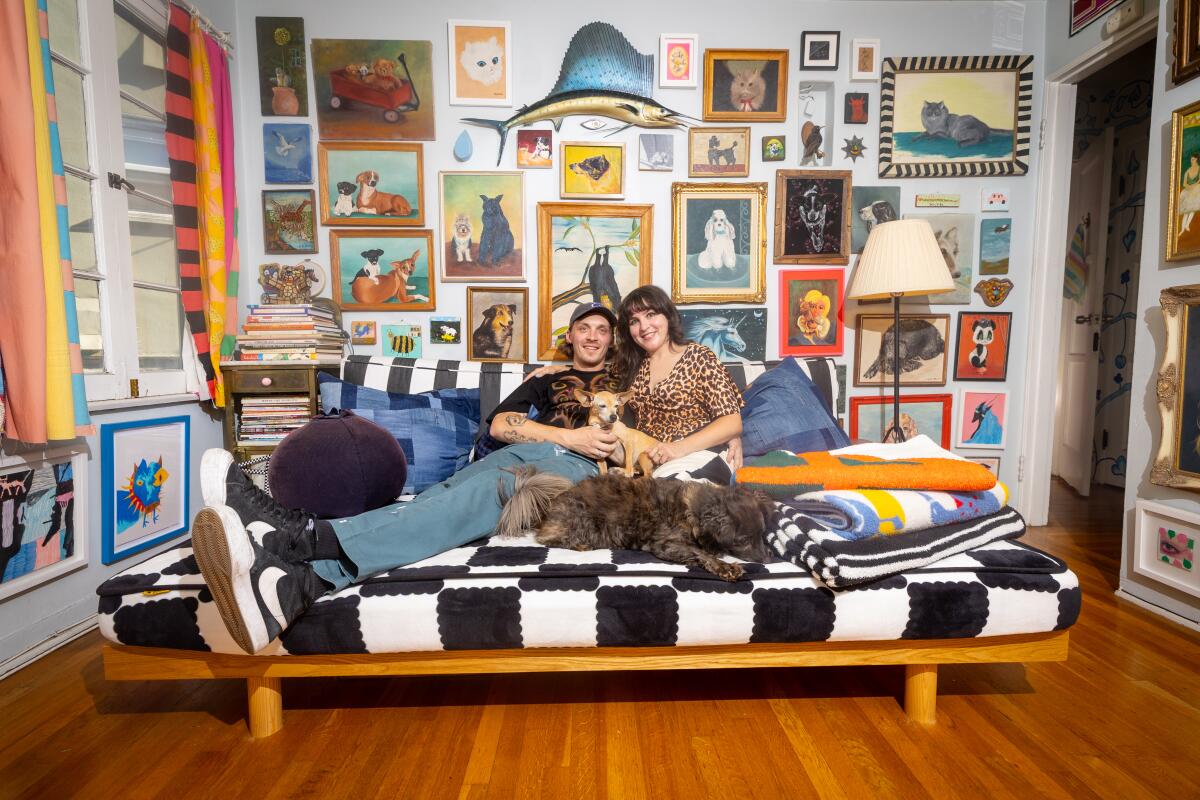 Isa Beniston sits on the sofa with partner Scotty Zaletel and her dogs.