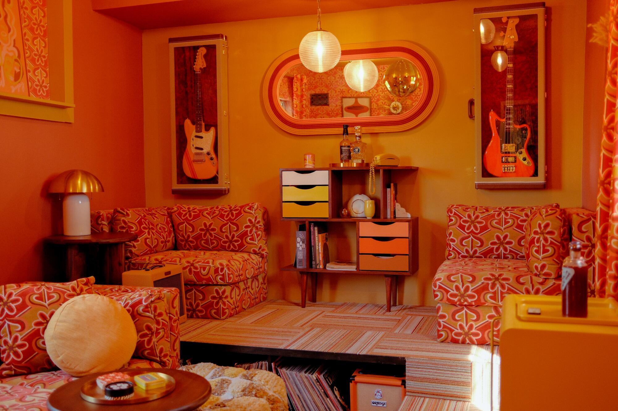 Colorful den decked out in orange and red printed fabrics.