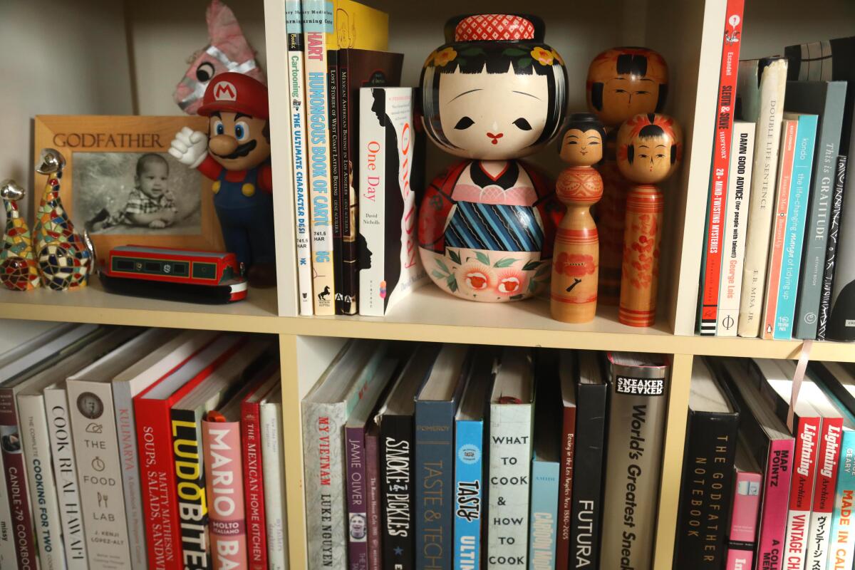 A bookshelf is filled with mementos, photographs and books.