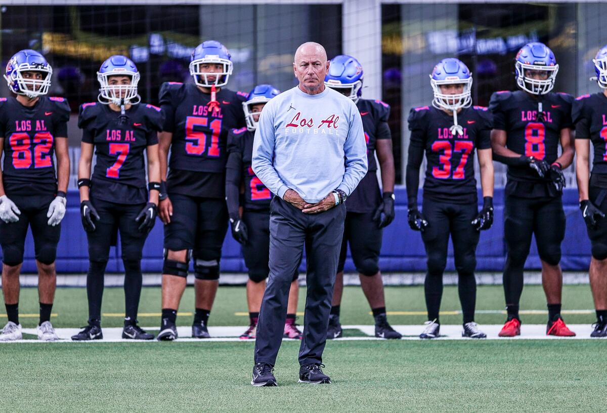 Los Alamitos football coach Ray Fenton stands with his players during an Alpha League opener at SoFi Stadium.