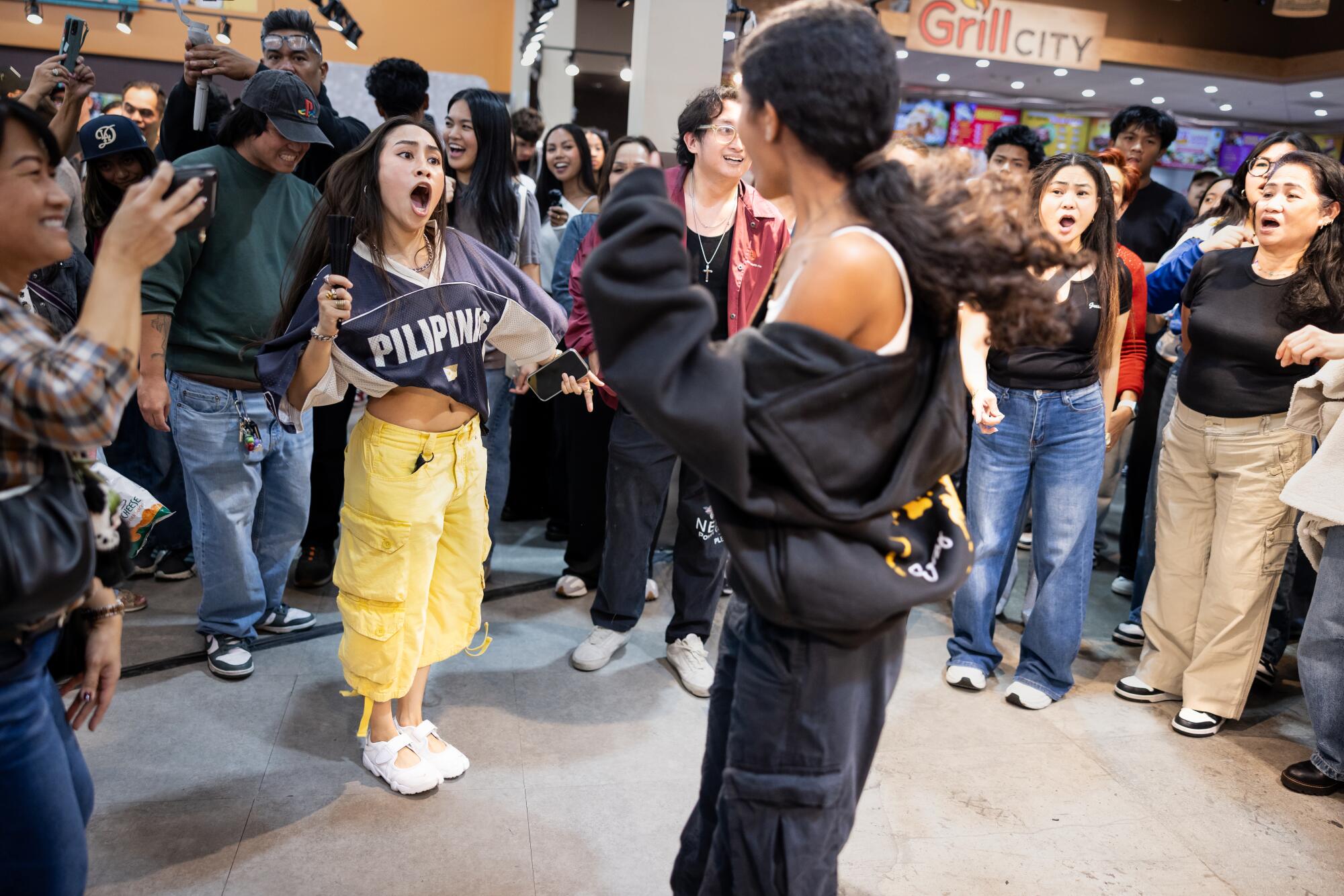 Two women dance in the middle of a circle.