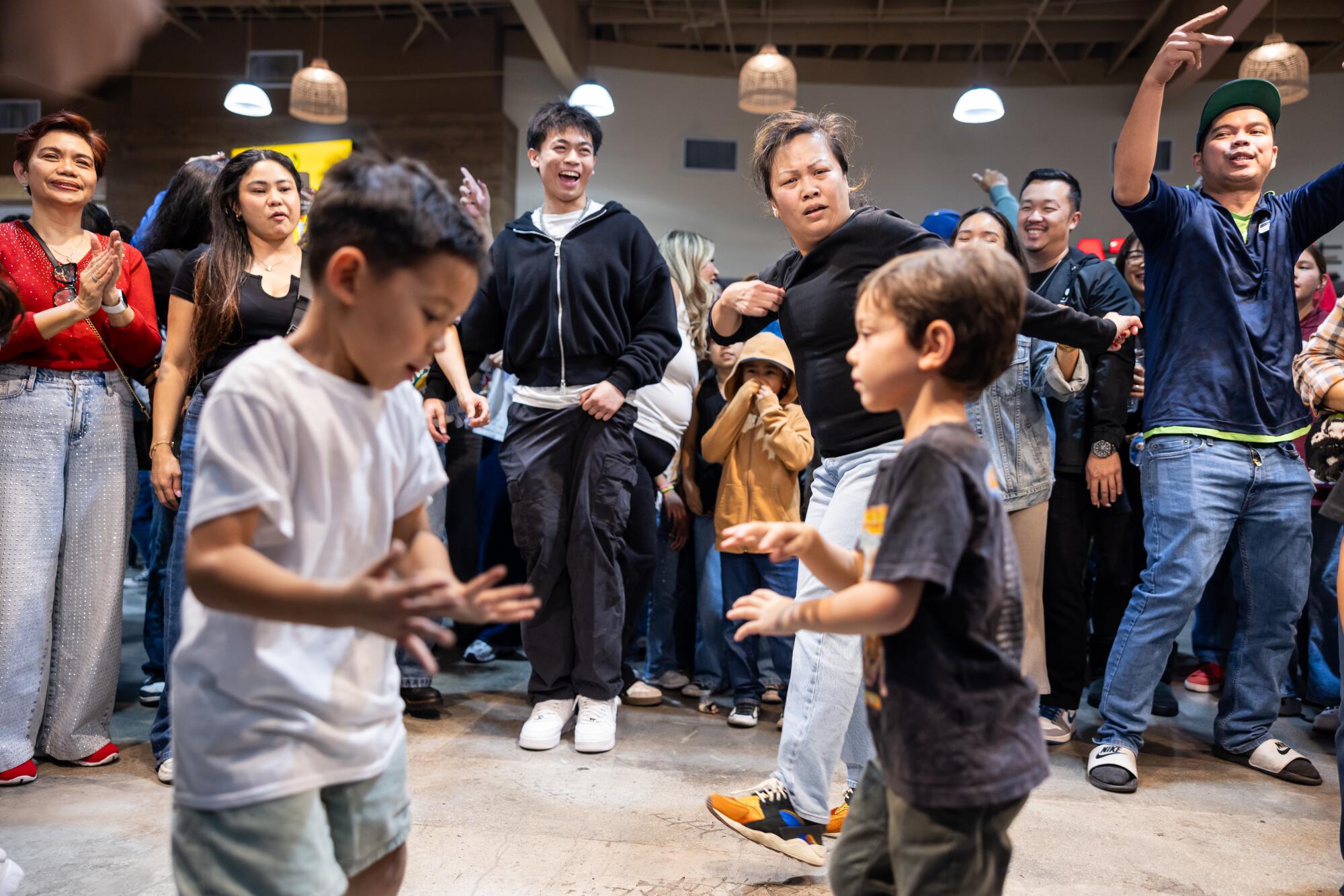 Children and adults dance in a circle.
