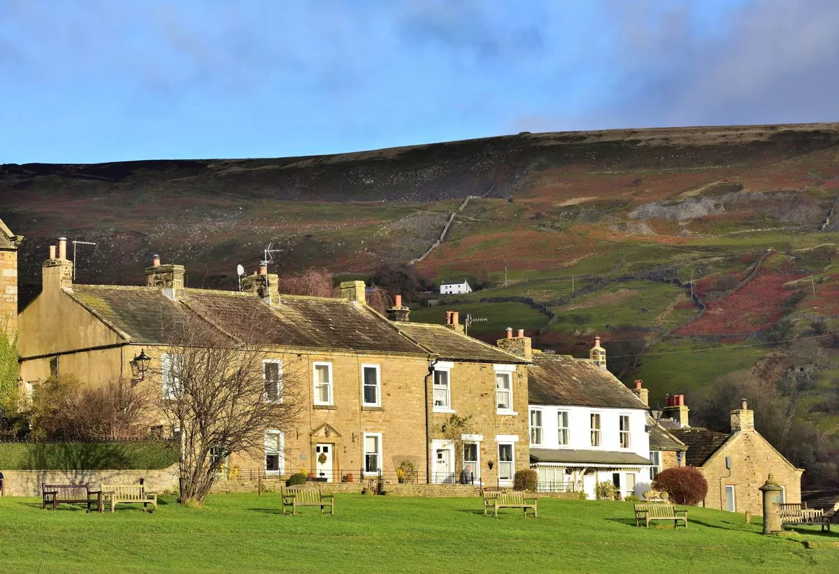 Houses in Reeth, lit by the winter sun and overlooked by the Fremington Edge.