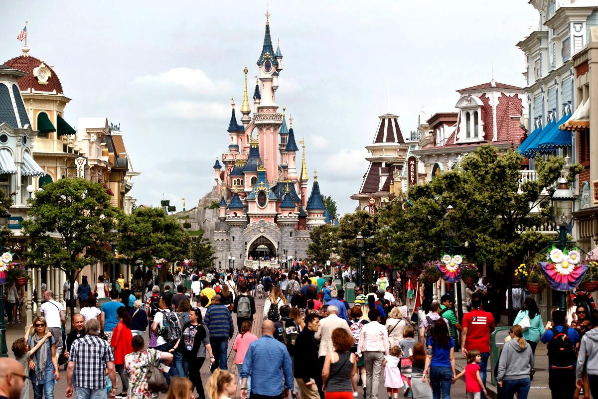 Visitors walk near Sleeping Beauty's Castle at Disneyland Paris.