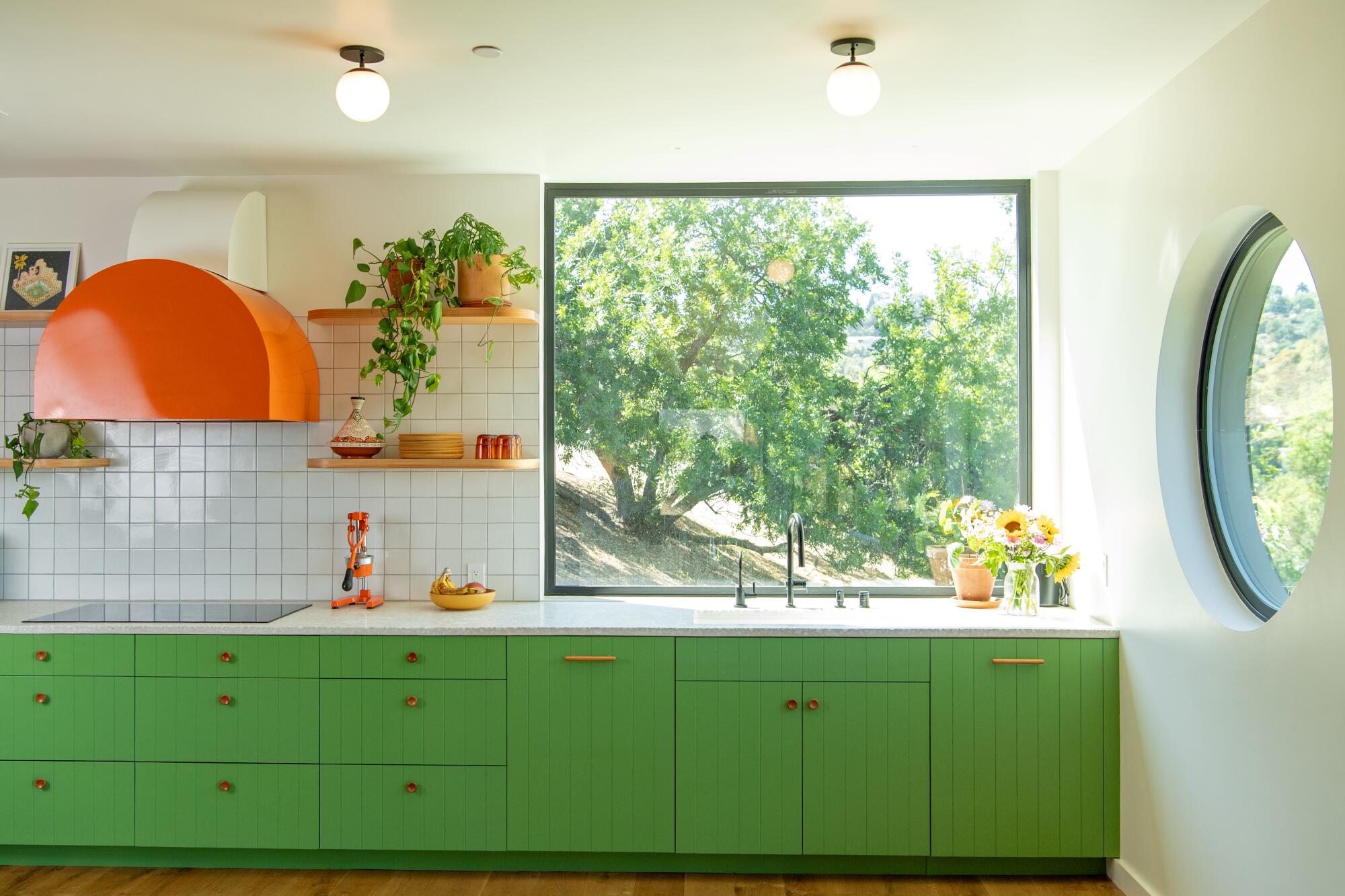 A kitchen with green cabinets and white tile