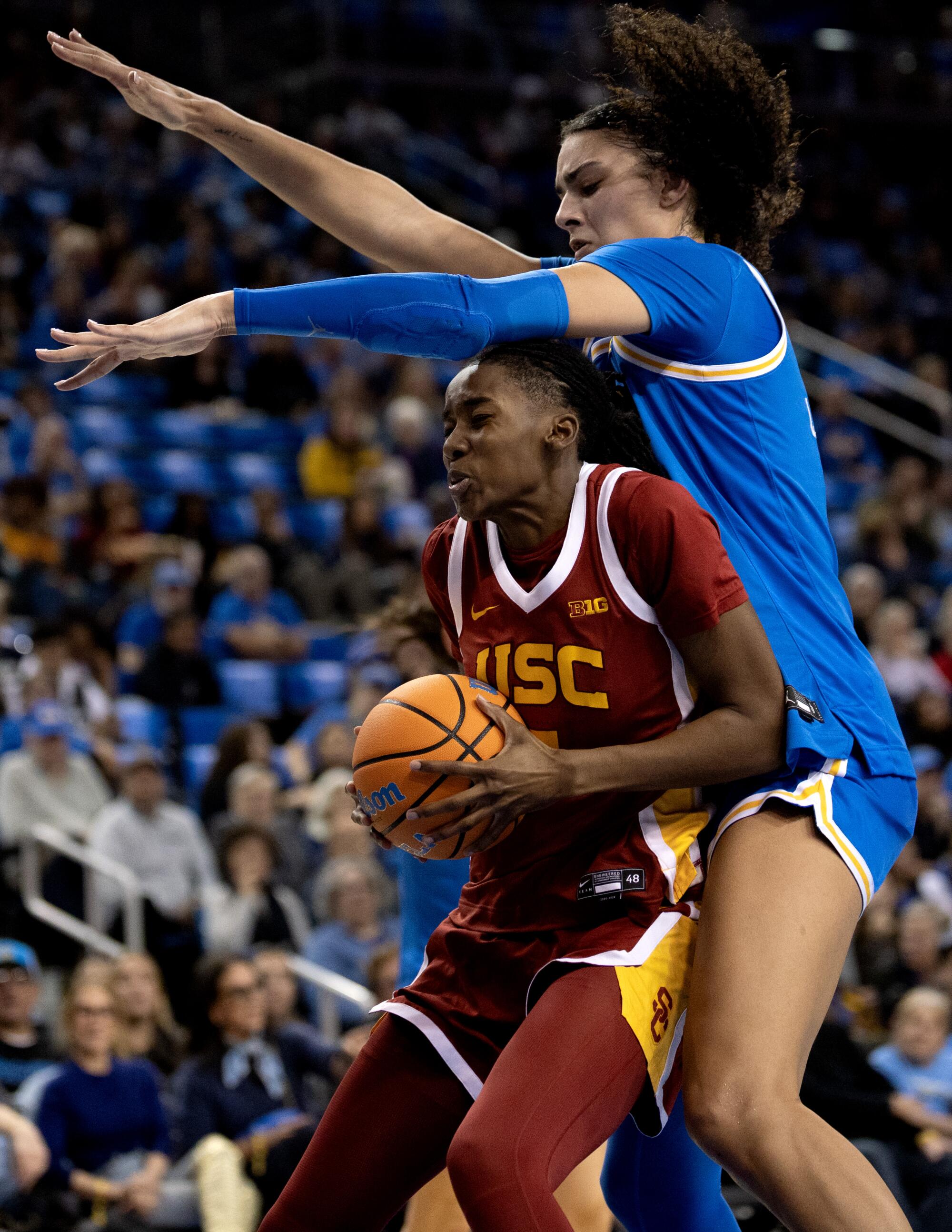 UCLA center Lauren Betts blocks USC forward Yakiya Milton's chance to put up a shot in the paint Saturday.