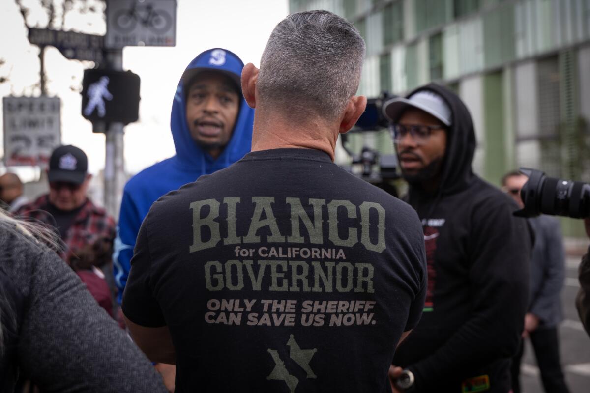 The back of a man talking to two men.