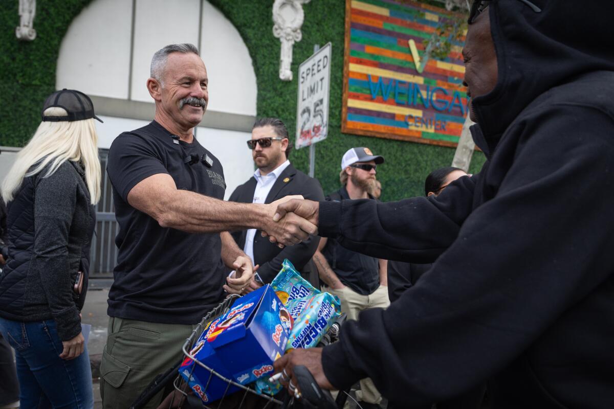 A man shakes hand with another.
