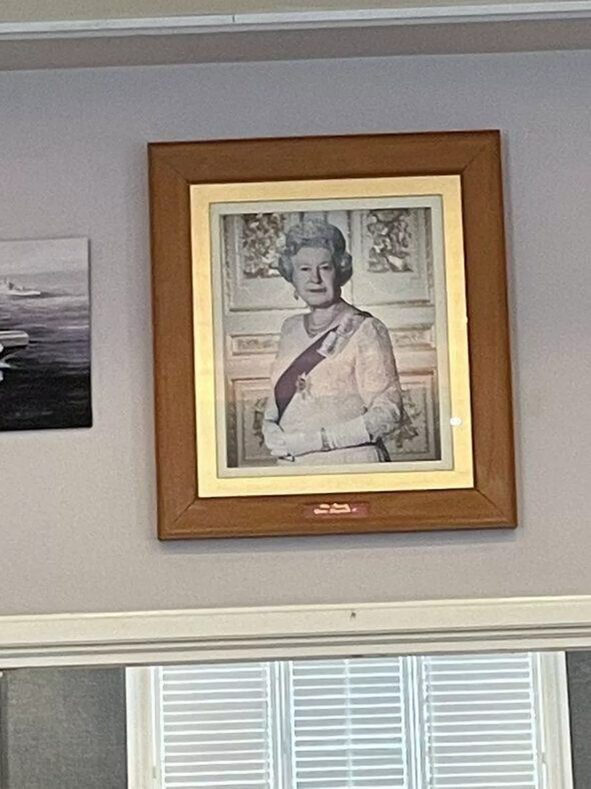 The portrait of Queen Elizabeth II loomed over the pub floor