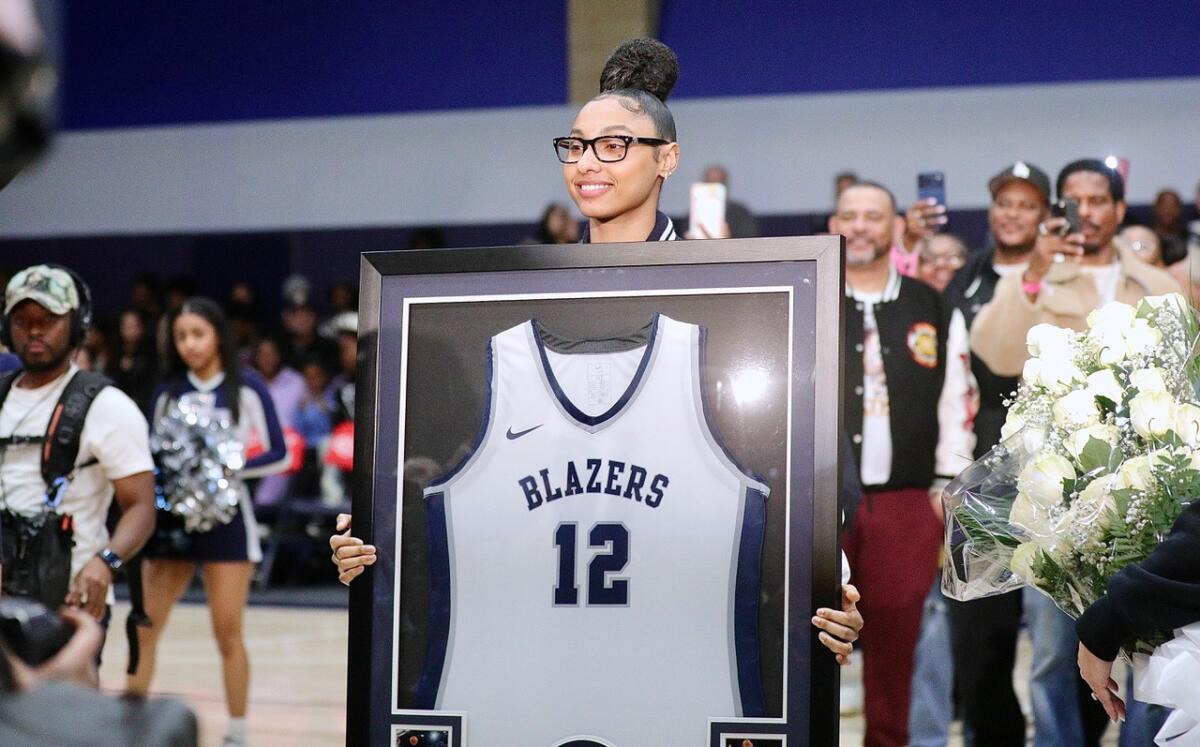 JuJu Watkins poses with her framed jersey during a retirement ceremony at Sierra Canyon High on Friday night.