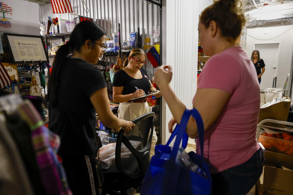 Volunteer help a Venezuelan immigrant at the storage units