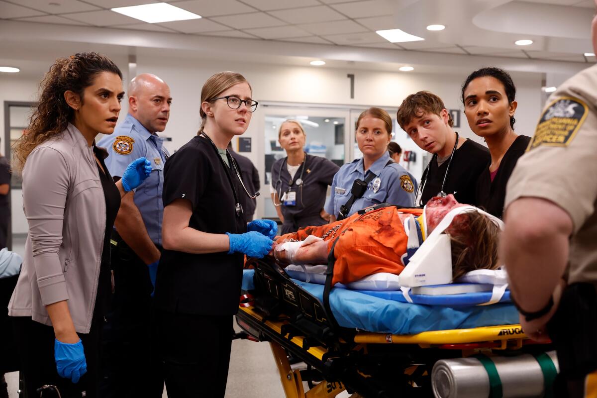 Hospital workers gather around a patient on a gurney