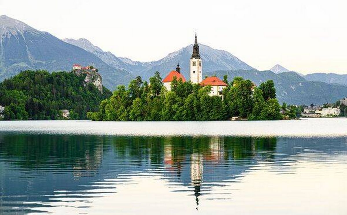 Lake Bled Slovenia and Bled Castle in background. Beautiful mountain lake with Church. Most famous Slovenian lake and island Bled with Church of the A