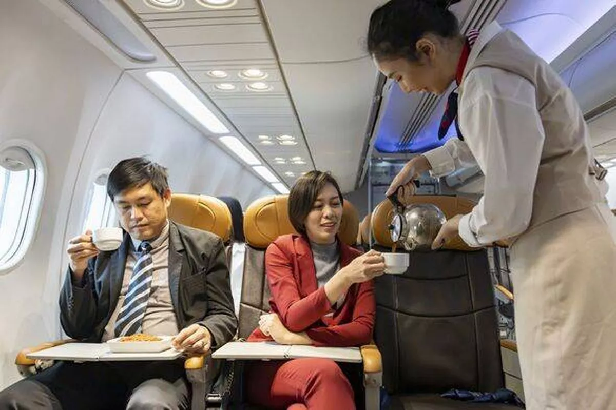 Flight attendant is serving coffee to the customer for in flight meal, airline travel and transportation concept