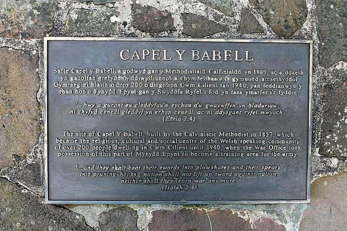 A commemorative plaque affixed to a stone wall bearing an inscription