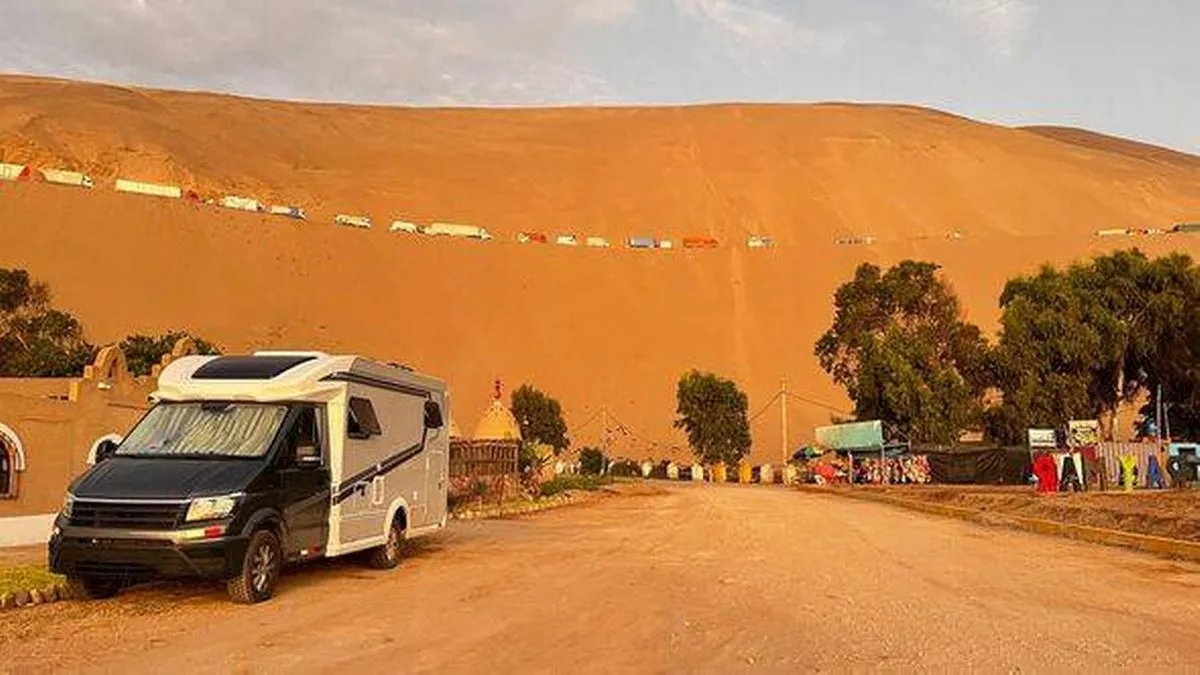 Modern RV motorhome while standing in Peru, Pan American Highway in dunes.