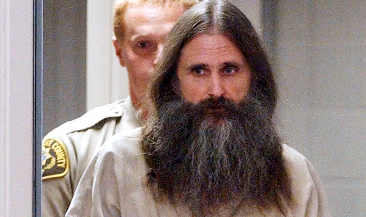 A man with a beard in prison uniform 