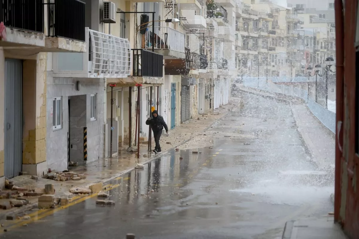 A pedestrian walks on a street affected by Storm Harry in Marsascala, eastern Malta