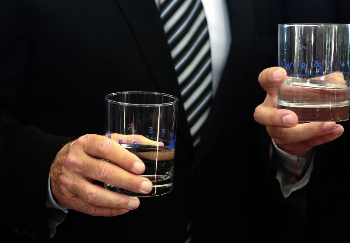 Gov. Jerry Brown holds glasses of reclaimed at the Orange County Water District Groundwater Replenishment System. (Allen J. Schaben/Los Angeles Times)