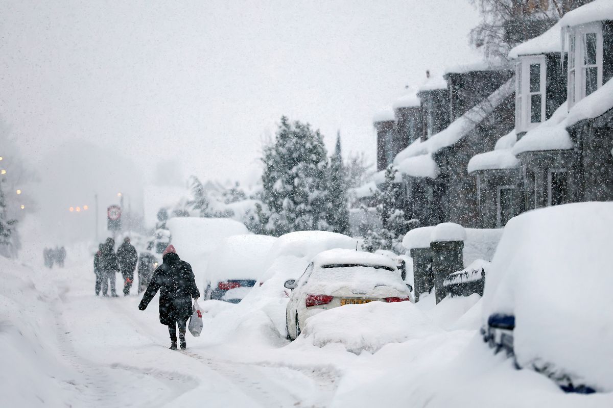People walk in Main Street Alford in heavy snow