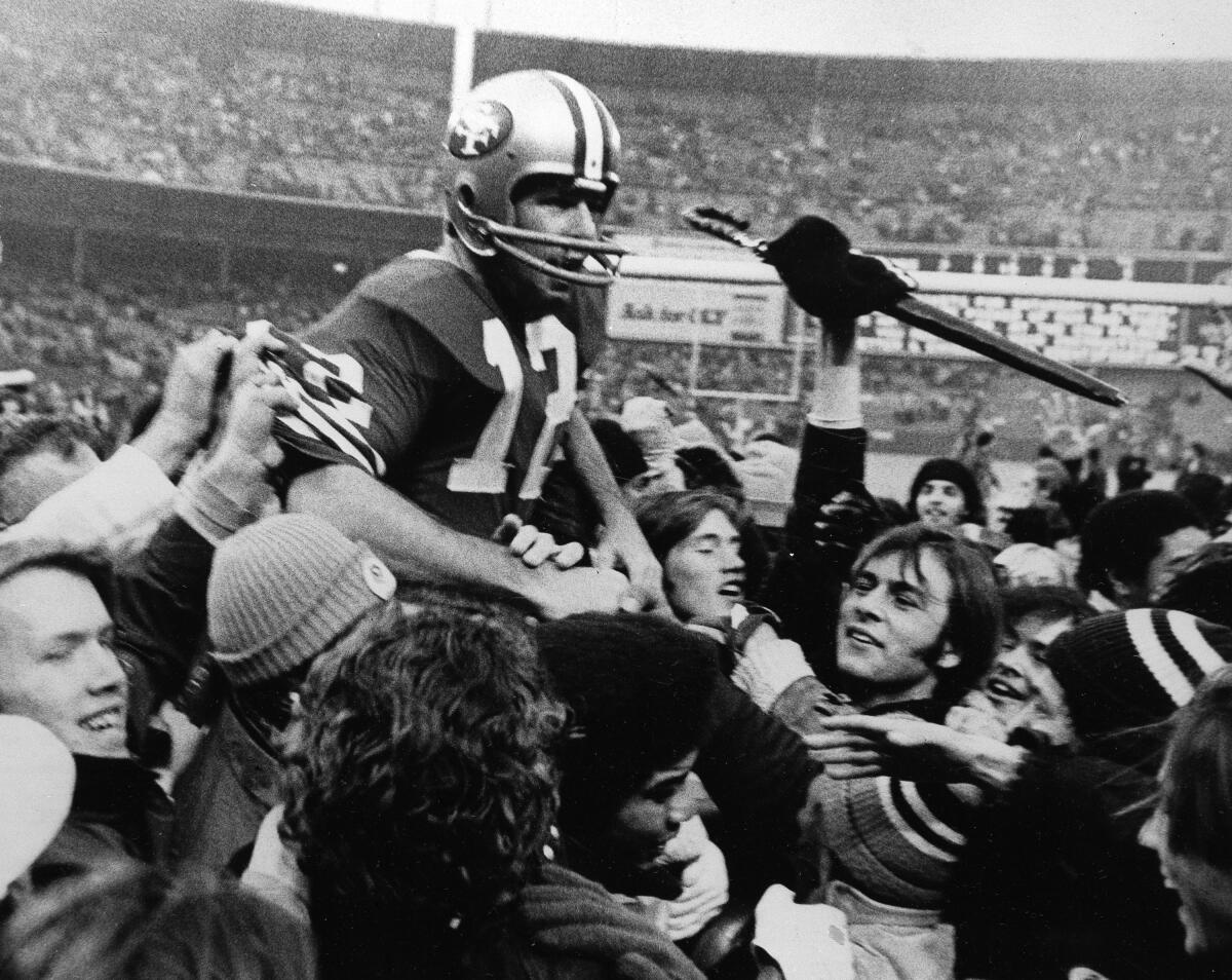 San Francisco quarterback John Brodie gets a ride on the shoulders of an admiring crowd following a win in 1972.