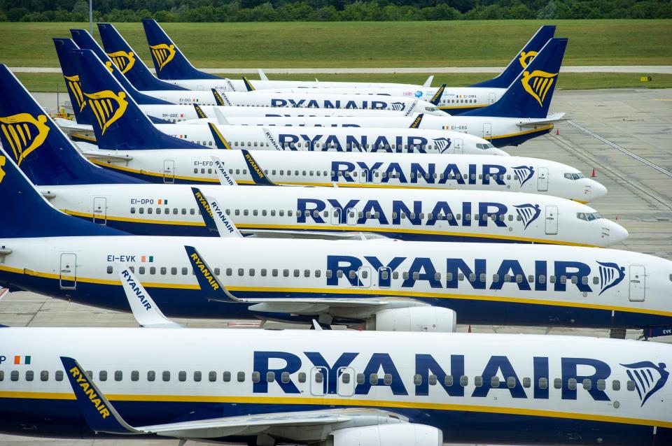 Multiple grounded Ryanair planes lined up on the tarmac at Stansted Airport.